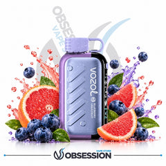 A Vozol Grapefruit disposable vape device in lavender purple and black, surrounded by fresh grapefruit slices, blueberries, and purple liquid splashes on a white background with Obsession branding.