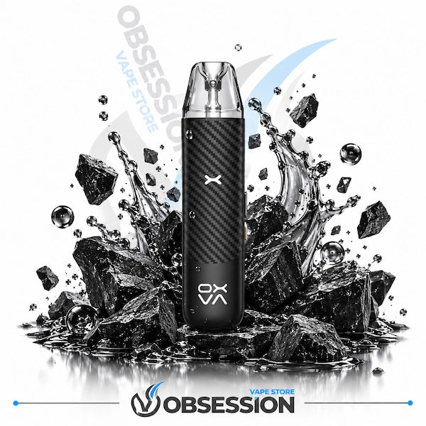 A black carbon-fiber-textured disposable vape device with a clear mouthpiece stands centered on a reflective surface surrounded by black rocks and water droplets. The OBSESSION brand name and logo are visible on the device and as a large watermark/logo behind it, with smaller 'VAPE STORE' text near the bottom.
