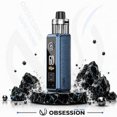 A blue and black vape device with a textured blue side panel and a digital display, standing on a black marble pedestal with dramatic black rocks and water splashes against a white background. The Obsession Vapec Store brand name is visible.