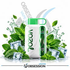 A Vozol vape device with a white body and green cap, surrounded by mint leaves, ice cubes, and water splashes on a white background. The Vozol brand name is printed vertically on the device, and an 'Obsession' store watermark is visible at the bottom.