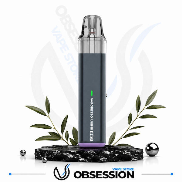 A dark gray disposable vape device labeled 'MADNESS VIBE' with a purple base, displayed on a black marble block with decorative green leaves and small metallic spheres. The background is white with a faint 'OBSESSION VAPE STORE' watermark, and the 'OBSESSION VAPE STORE' logo is displayed at the bottom.
