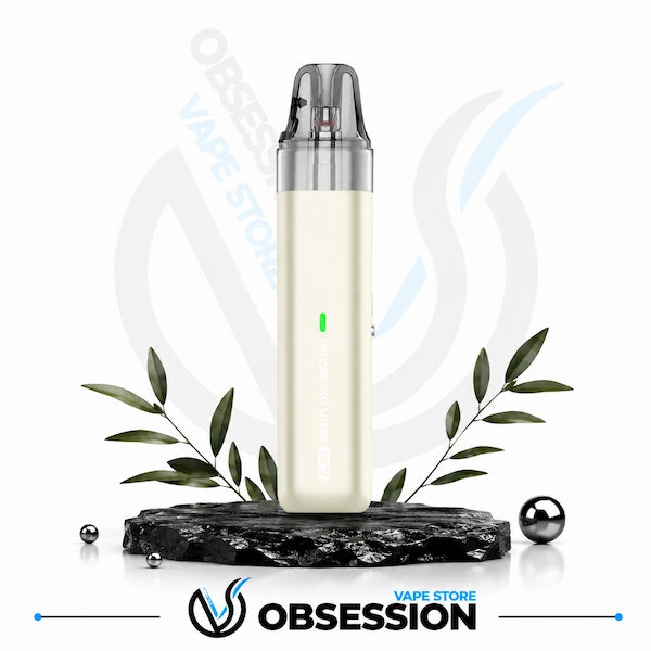 A slim cylindrical vape device in off-white with a clear mouthpiece, displayed on a black marble base with decorative green leaves and metallic spheres. The Obsession Vape Store logo is visible at the bottom.