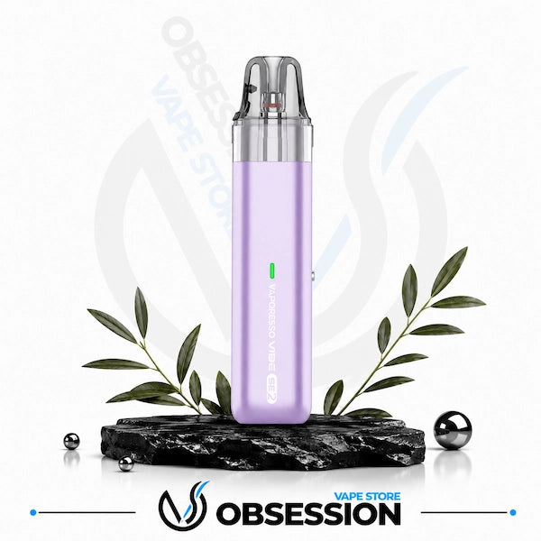 A lavender purple disposable vape device with a clear mouthpiece, displayed on a black marble base with decorative green leaves and metallic spheres. The Obsession Vape Store logo is visible at the bottom.