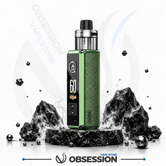 A green and black Obsession vape mod kit with a digital display, standing on a black marble base surrounded by decorative black rocks and metallic spheres against a white background with Obsession branding.