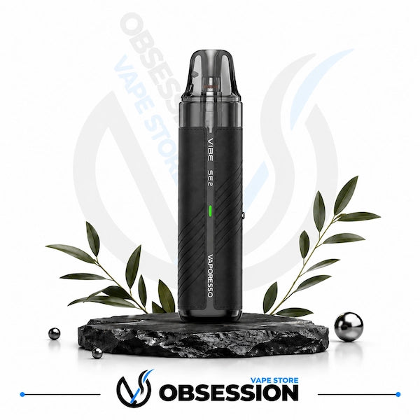 A black Vaporesso X2 vape device with a clear mouthpiece, standing upright on a dark stone base with decorative green leaves and metallic spheres against a white background. The Obsession Vape Store logo is visible at the bottom.