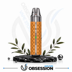 A Vibro V4 vape device with a metallic orange and brown checkerboard patterned body, displayed on a black marble stand with decorative leaves and metallic spheres against a white background with Obsession Vape Store branding.