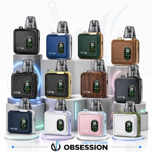 Twelve XLT1 vape devices in various colors are arranged in a 3x4 grid on white display pedestals. The devices feature square bodies with digital screens showing battery percentages, and are topped with clear mouthpieces.