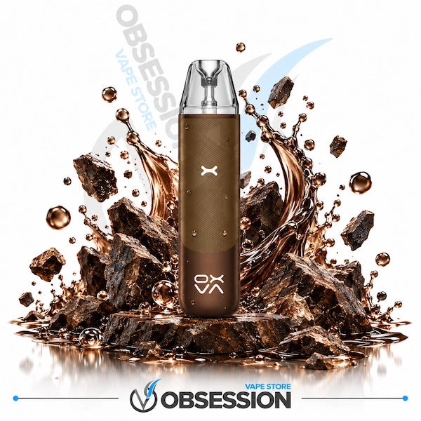 A brown disposable vape device stands upright in front of a stylized splash of dark brown liquid and rock fragments on a white background. The device has a clear mouthpiece and visible OBSESSION branding near the bottom.