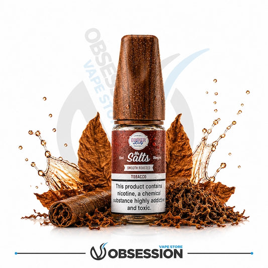 Smooth Tobacco Salt 30ml By Dinner Lady.webp shows a Dinner Lady Smooth Roasted Tobacco Salts vape juice bottle with a textured, wood-grain pattern cap. The bottle is surrounded by large dried tobacco leaves, a rolled cigar or tobacco leaf on the bottom left, a pile of loose shredded tobacco at the base, and dynamic amber or caramel-tinted liquid splashes on a white background.