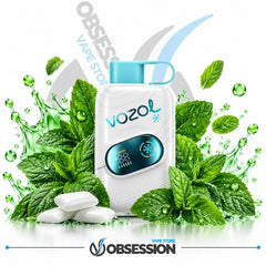 A white Vozol vape device with a light blue mouthpiece and digital screen, surrounded by green mint leaves, water droplets, and white candy pieces on a white background with Obsession and Vozol branding.