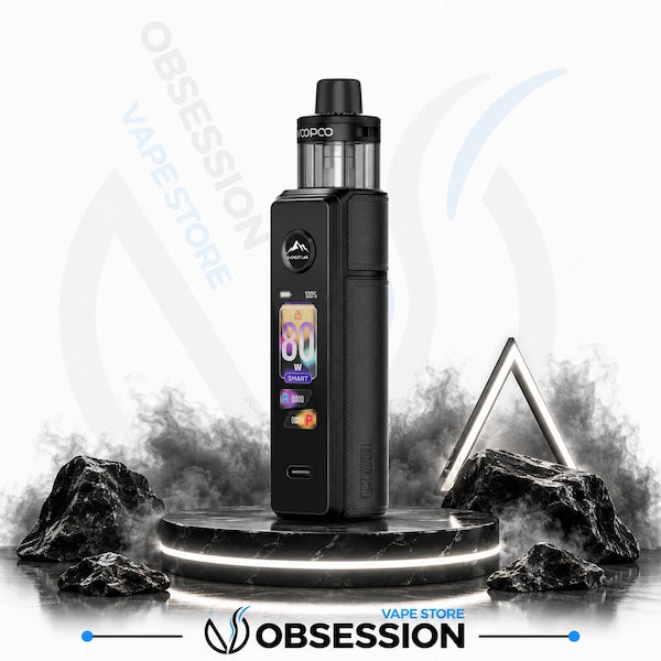 A black Obsession vape device with a digital screen and COPOO tank, displayed on a black marble pedestal with smoke effects and rocks against a white background with store watermarks.