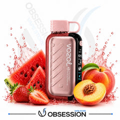 A Vozol disposable vape device in a metallic rose gold finish with a pink mouthpiece, surrounded by fresh watermelon slices, strawberries, and peaches with a red liquid splash effect, on a white background with the Obsession brand logo at the bottom.
