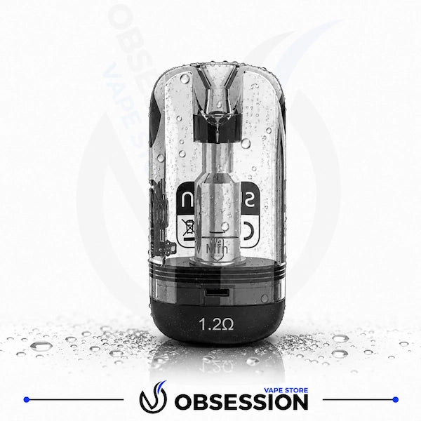 Suorin SE Replacement 2ml Cartridge.webp shows a replacement pod cartridge designed for the Suorin SE pod system. The clear, transparent plastic cartridge is covered in small water droplets and stands upright on a wet, reflective white surface with scattered water droplets.