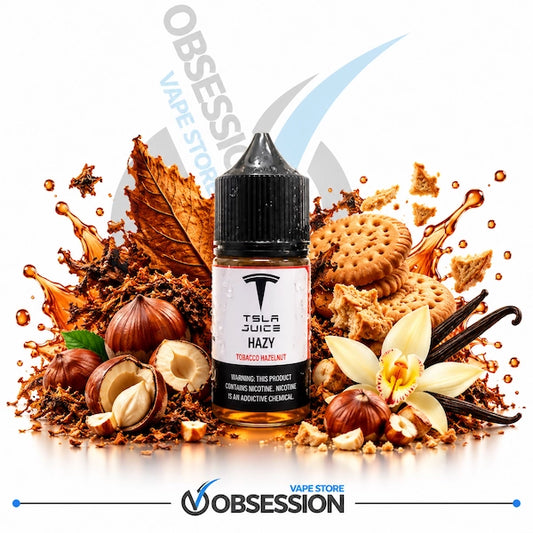 A 30ml bottle of TSLA Juice Hazy Tobacco Nicotine e-liquid centered on a white background, surrounded by flavor-themed props including hazelnuts, cookies, vanilla flowers, cinnamon sticks, and a tobacco leaf. The Obsession Vape Store logo is visible at the bottom.