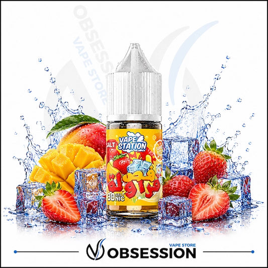 Vape Station Strawberry Super Ice (Fas Farawilah) Salt 30ml.webp shows a Vape Station Strawberry Super Ice (Fas Farawilah / فص فراولة) SaltNic vape juice bottle with a clear, droplet-covered cap. The bottle features a bright yellow label with bold Arabic typography and sits centrally in a vibrant arrangement of fresh fruit and cooling elements