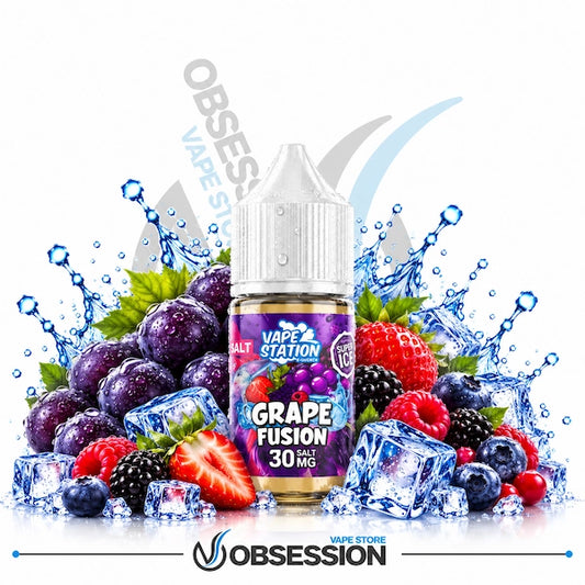 A bottle of Grape Fusion e-liquid by Vape Station Salt is centered against a white background, surrounded by fresh grapes, berries, strawberries, ice cubes, and water splashes. The label reads 'GRAPE FUSION 30 MG' and shows the Vape Station Salt logo.